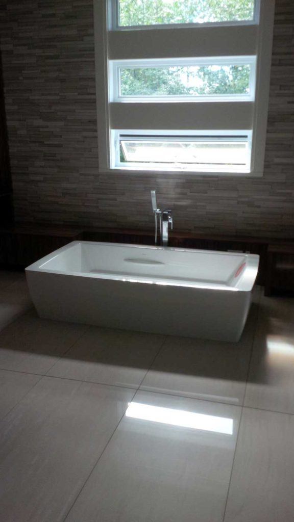 White square sink, still uninstalled, sits in bathroom under a window