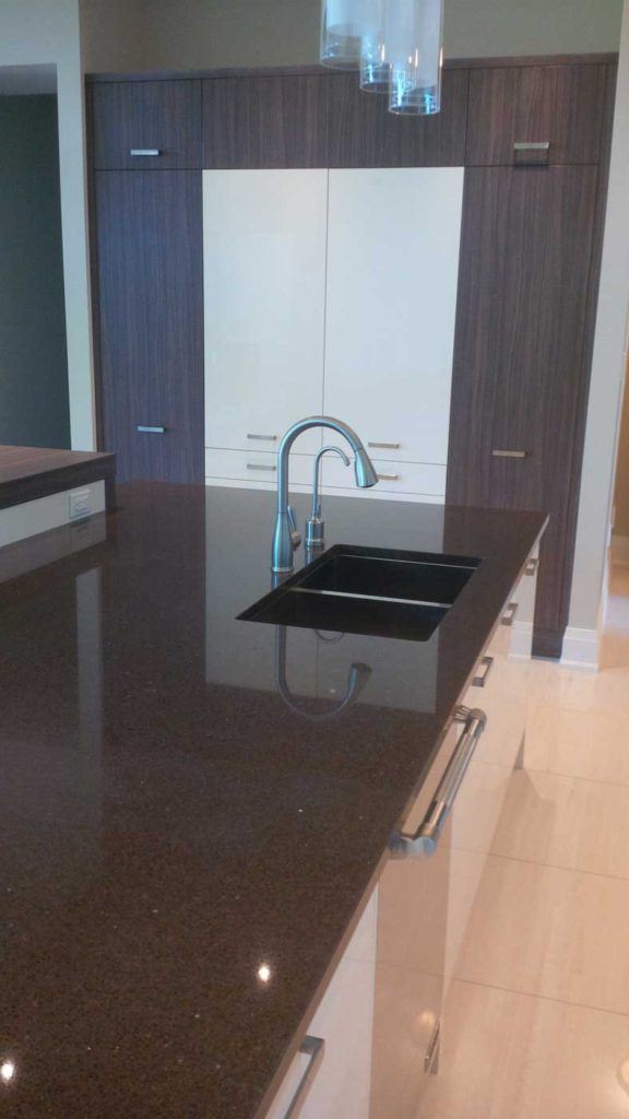 Double-sink in a kitchen island with black countertop