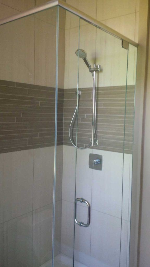 Stand-up shower with glass door and beige & brown tiles